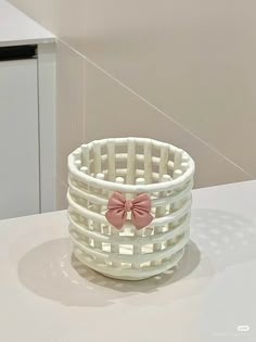 a white basket with a pink bow on it