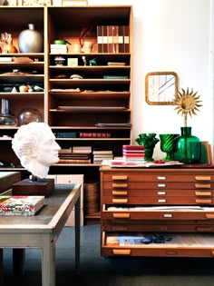 a living room filled with lots of furniture and bookshelves covered in vases