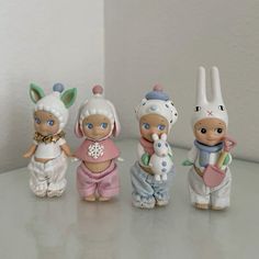 five little figurines sitting on top of a table