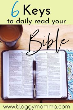 an open bible on top of a wooden table next to a cup of coffee