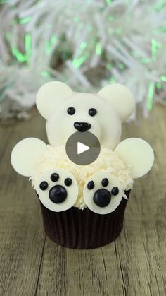 a cupcake with white frosting and teddy bear decorations