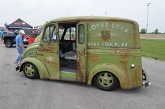 an old green truck parked in a parking lot