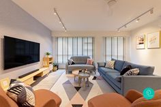 a living room filled with furniture and a flat screen tv mounted to the side of a wall