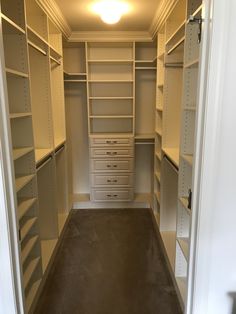 an empty walk in closet with lots of shelves and drawers on the walls, along with carpeted flooring