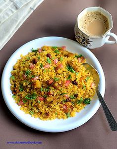 a white plate topped with rice next to a cup of coffee