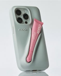 an iphone case with a pink toothbrush and tube on the phone holder that is attached to it