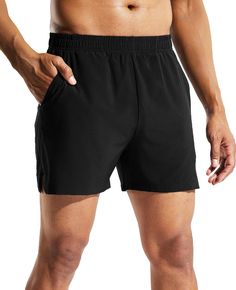 a man in black shorts with his hands on his hips and one hand on his hip