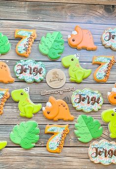 decorated cookies are arranged on a wooden table with the word jungle spelled in cursive letters