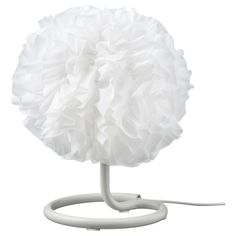 a white table lamp with ruffles on it's base and a cord plugged in