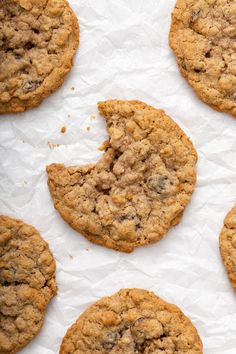 chocolate chip cookies on top of white paper with crumbs in the middle and one cookie missing