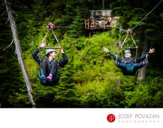 two people are zipping through the air on ropes