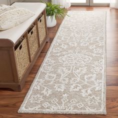 a large white rug on top of a hard wood floor next to a bed and window