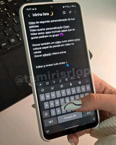 a person holding up a cell phone with a keyboard on it