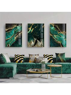 three paintings hang on the wall above a green couch and coffee table in a living room