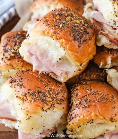 ham and cheese sliders piled on top of each other with poppy seed sprinkles