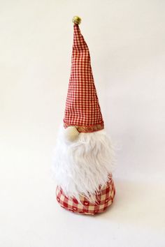 a red and white gnome's hat on top of a checkered table cloth