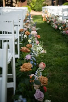 rows of white chairs lined up with flowers on the grass in front of each chair