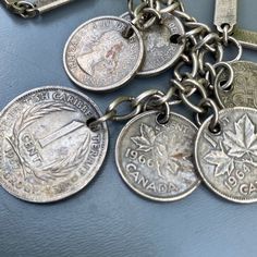 Boho style ~ Vintage ~ silver plated ~ Canadian coin charm ~ wide chain link ~ necklace ~ Circular spring clasp at the end ~ coins are from mid 20th century Unsigned Materials : Silver plated metal ( probably copper as base metal ) . Measurements : Measures 24 1/2 inches in wearable length x 1/4 inches max width ~ Central coin dangles 2 3/4 inches in drop length x max width of 3/4 inches Weighs 53 grams on my weighing scale. Condition : Overall in good vintage condition ~ No major dent or ding s Vintage Sterling Silver Coin Necklace, Vintage Silver Coin Charm Necklaces, Vintage Silver Coin Necklace For Jewelry Making, Vintage Silver Chain Necklace Gift, Vintage Silver Chain Necklace For Gift, Vintage Sterling Silver Coin Necklace In Silver, Vintage Charm Necklaces With Round Shape, Silver Medallion Charm Necklaces With Vintage Charm, Silver Vintage Charm Coin Necklace