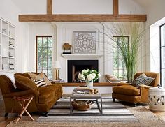 a living room with couches, chairs and a fire place in the middle of it