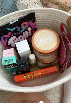 a white basket filled with lots of different types of cosmetics and personal care items on top of a table