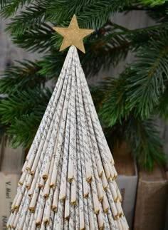 a small christmas tree made out of rolled up paper and gold stars on the top