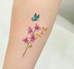 a small flower tattoo with a butterfly on the left side of the arm and behind it is pink flowers