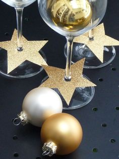 two wine glasses with gold and white ornaments on them next to one glass filled with champagne