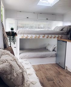 two bunk beds in a small room with wood flooring