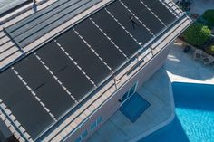 an overhead view of a swimming pool with solar panels on the roof and sidewalls