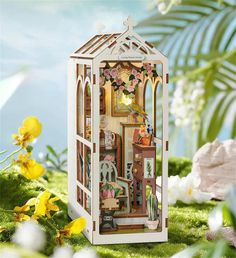 a doll house in the shape of a birdcage with flowers and plants inside