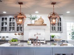 the kitchen is clean and ready for us to use it's lighting fixtures are hanging from the ceiling