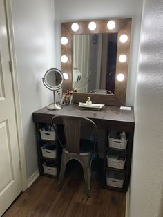 a vanity with lights on and a chair in front of the mirror that is next to it