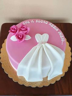 a pink and white wedding cake with flowers on top