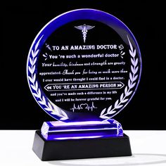 a blue glass award with an engraved plaque on it's base and the words to an amazing doctor