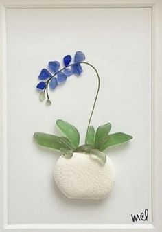 a blue flower is in a white vase