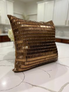 a gold pillow sitting on top of a white counter