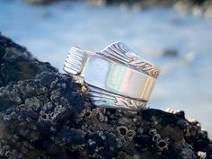 a silver ring sitting on top of a rock