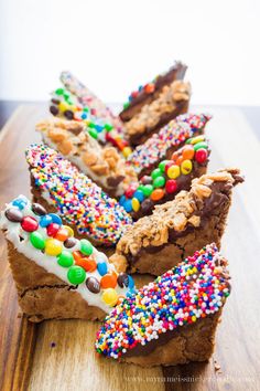 candy dipped brownies with sprinkles are on a wooden cutting board and the words, candy dipped brownies