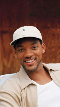 a man wearing a hat and smiling for the camera