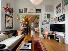 a living room filled with furniture and pictures on the wall