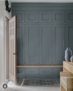 an open door leading to a large room with blue cabinets and drawers on either side