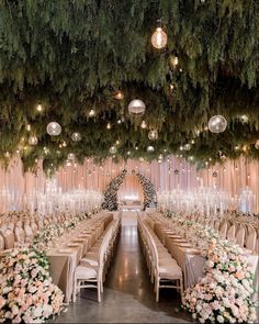 an indoor wedding venue with tables, chairs and chandeliers hanging from the ceiling