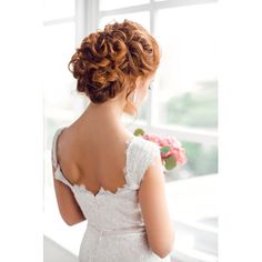 a woman in a wedding dress looking out the window