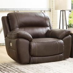 a brown reclining chair sitting on top of a rug