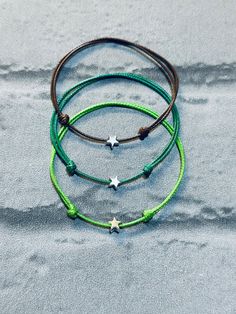 "A simple waxed cord stack of 3 bracelets which are fully adjustable. This stack features light green, dark green and chocolate brown  - our \"Grounded to the Earth\" stack is simply beautiful!  One size fits most, simply slide to open, place on wrist and slide closed 🧡 Silver plated sliding star charm in the centre ⭐️ Also available in an anklet style ✌🏼 The perfect little gift for you or your friends.  Will come in complimenty gift wrap. If ordering multiples as gifts and would like each one individually wrapped, please leave a note in the note to seller box upon checkout ✨if no note is left, they will be packaged in one gift bag ✨ To prolong the life of your new bracelet - take off before showering/bathing and avoid direct contact with lotions,perfumes and sprays. Adjustable string wi Fishtail Friendship Bracelets, Hen Party Ideas, Wax Cord Bracelet, Bracelet String, Tree Of Life Bracelet, Pride Bracelet, Buddha Jewelry, Bracelet Christmas, Women Anklets