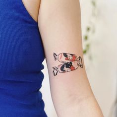 a woman's arm with two fish tattoos on the left side of her arm