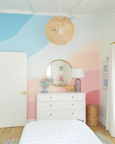 a bedroom with pink, blue and white stripes painted on the walls