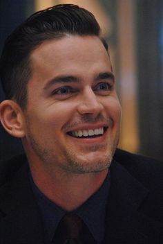 a smiling man in a suit and tie