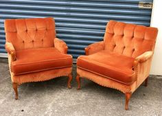 two orange chairs sitting next to each other in front of a blue garage door with shutters