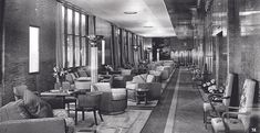 an old black and white photo of a long hallway with lots of furniture in it